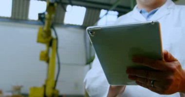 Robot mühendisi dijital tablet kullanarak düşük açılı görünümü. Düşünceli mühendis dijital tablet 4 k tutan
