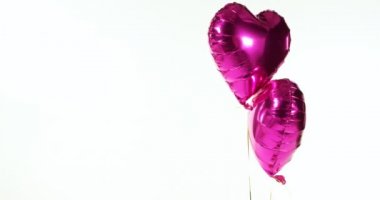 Mor balon havada yüzer. Balonlar dize 4 k bağlı kalp şeklinde