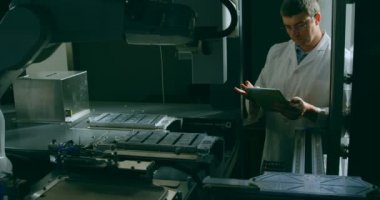 Robot mühendisi dijital tablet depoda kullanma. Mühendis incelemek robot makine 4k