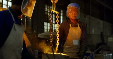 Molted metal atölyesinde konteyner taşıyan işçilerin grup. Birlikte 4 k atölyede çalışan işçiler