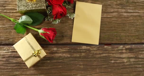 赤いバラ ギフト ボックス 木製の表面カード ギフト ボックス のまわりの赤いバラの花束 — ストック動画