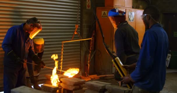ワーク ショップで金型に溶融金属を注ぐの労働者のグループ 一緒に を労働者 — ストック動画