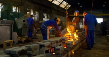 Alt kapsayıcı döküm atölyesinde dan erimiş metal döküm. Döküm atölyesinde 4 k işçisi