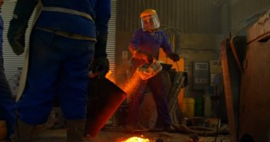 Erimiş metal kalıp Atölyesi'nde dökme işçilerin grup. İşçilerin birlikte 4 k çalışma