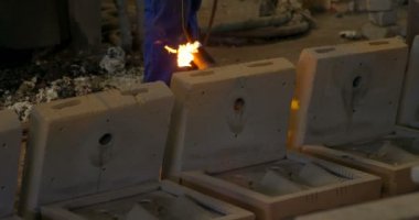 Mid section of worker heating metal mold with blow torch in foundry workshop. Worker working in foundry workshop 4k
