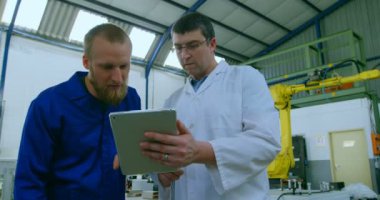 Robot mühendisleri üzerinde dijital tablet tartışıyor. Dijital tablet 4 k tutan mühendisi