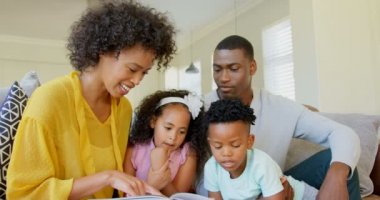 Siyah aile oturma odasında hikaye kitabı okuma önden görünümü. Siyah aile 4 k oturma odasında rahatlatıcı