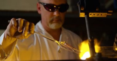 Olgun erkek işçinin cam üfleme cam fabrikasında yakın çekim. Olgun erkek işçi cam 4 k Isıtma