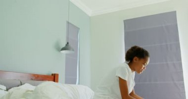 Siyah kız yatak odasında evde dijital tablet kullanarak yan görünüm. Yatak yatak 4 k üzerinde oturan siyah kız