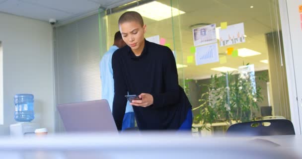 近代的なオフィスにラップトップに取り組んでいる間携帯電話を使用して若い白人女性エグゼクティブのフロント ビュー で働く男性の同僚 — ストック動画
