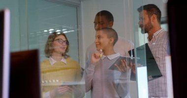 Genç yarış iş takım modern office panosunda cam üzerinde tartışırken karışık. Genç karışık yarış iş takım birlikte çalışan 4 k