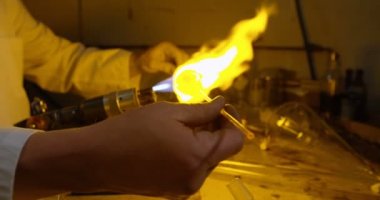 Erkek işçi cam üfleme cam fabrikasında orta bölümü. Erkek işçi üfleme meşale 4 k Isıtma