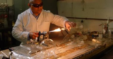 Cam üfleme cam fabrikasında erkek işçi önden görünümü. Olgun erkek işçi cam 4 k Isıtma