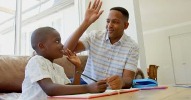 Siyah baba oğlu evde ödev, siyah baba ve oğul birbirlerine 4 k yüksek beş vererek yardımcı önden görünümü