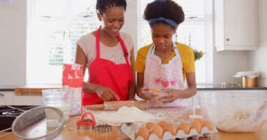 Siyah anne ve kızı evde mutfakta kurabiye önden görünümü. Siyah kız un 4 k üzerinde Yumurta çatlama