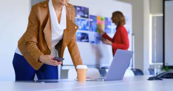近代的なオフィスに携帯電話を使用して若い白人女性エグゼクティブの側面図です で働く女性の同僚 — ストック動画