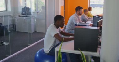 Yan görünümü karışık yarış iş grubunda modern ofis masasında Masaüstü PC. 4 k masada oturan karışık yarış iş takım