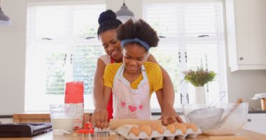 Siyah anne ve kızı evde mutfakta kurabiye önden görünümü. Siyah anne kızını bir hamur 4 k için yardım