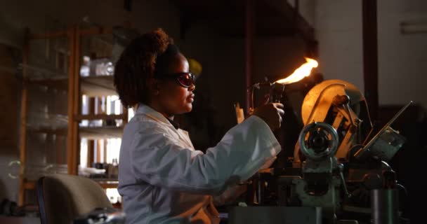 玻璃厂黑人女工吹玻璃的侧视图 黑色女工加热玻璃4K — 图库视频影像