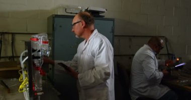 Dijital tablet cam fabrikasında beyaz erkek işçisi. İş arkadaşınız Isıtma cam 4k