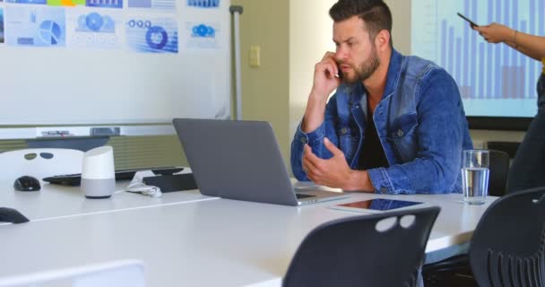 年轻的高加索商人在现代办公室用手机交谈 在后台4K 中使用数字平板电脑的同事 — 图库视频影像