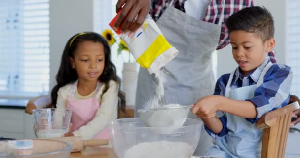 黒人の父と彼の子供が台所で食事の準備のフロント ビュー を自宅に彼の子供と対話する黒人の父 — ストック動画