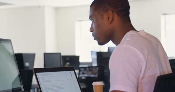 年轻黑人男性高管在办公室办公桌前工作的侧视图 年轻的黑人男性高管使用台式电脑4K — 图库视频影像