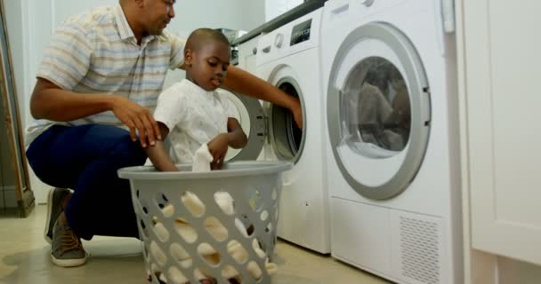 Zijaanzicht Van Zwarte Vader Zoon Kleren Wassen Wasmachine Thuis Zwarte — Stockvideo