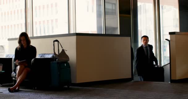亚洲商人走在酒店大堂携带行李 在大厅4K 从事数字平板电脑工作的高加索女商人 — 图库视频影像