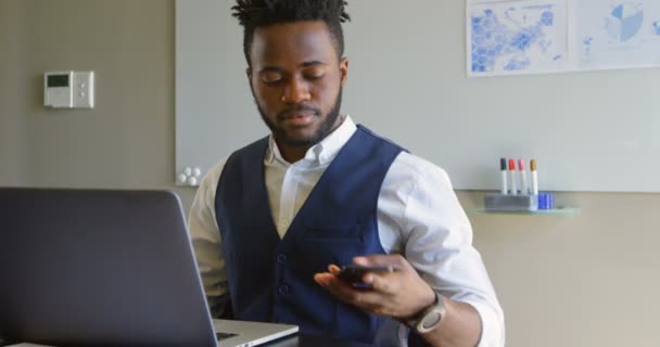 Вид Спереди Молодого Чернокожего Бизнесмена Сидящего Ноутбуком Разговаривающего Мобильному Телефону — стоковое видео
