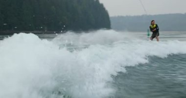 Önden Görünümü üzerinde şehir nehre wakeboard yapan beyaz delikanlı. Wakeboard ip 4 k tutan binici