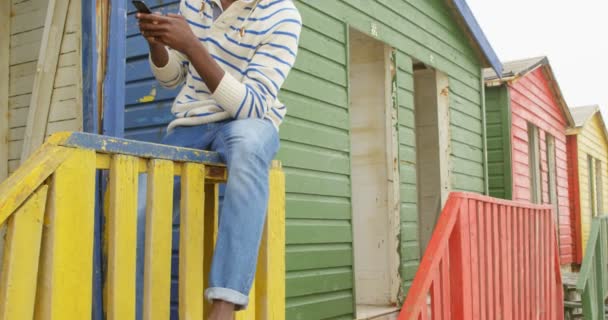 Vooraanzicht Van Jonge Zwarte Man Texting Mobiele Telefoon Zittend Leuning — Stockvideo