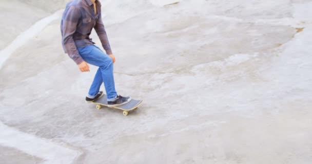 在滑板公园的坡道上玩滑板的年轻白人男子的侧视图 在阳光下滑板的人4K — 图库视频影像