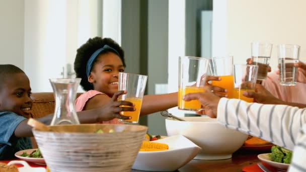 在餐桌上看到黑色多代家庭的烤杯果汁和水 他们面带微笑 一起吃食物 — 图库视频影像