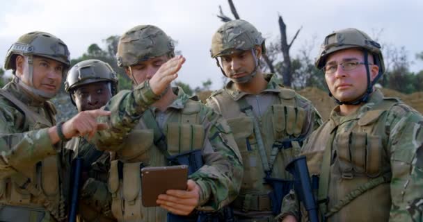 トレーニング中にデジタル タブレットを使用して軍の兵士のフロント ビュー デジタル タブレット 以上議論する軍の兵士 — ストック動画