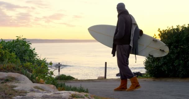 Bakifrån Mitten Vuxen Man Med Surfbräda Stående Vägen Nära Havet — Stockvideo