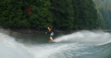 Önden Görünümü üzerinde şehir nehre wakeboard yapan beyaz delikanlı. Wakeboard ip 4 k tutan binici