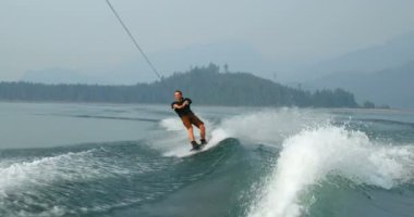 Önden Görünümü üzerinde şehir nehre wakeboard yapan beyaz delikanlı. Wakeboard ip 4 k tutan binici