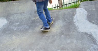 Genç adam kaykay parkı içinde rampa üzerinde kaykay hüner pratik düşük bölümü. 4 k ışığında saygısız kaykay dostum