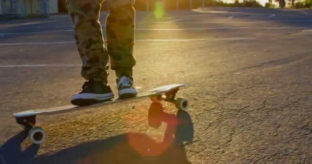 在乡间路上溜冰的年轻滑板的低部分 在阳光下骑在长板4K — 图库视频影像