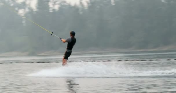 市湖でウェイク ボードのトリックを行う白人の若い男のリアビュー ウェイク ボードのランプを使用して のトリック ライダー — ストック動画