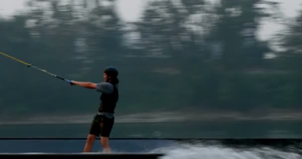 白人の若い男市湖でウェイク ボードのトリックを行います ウェイク ボードのランプを使用して のトリック ライダー — ストック動画