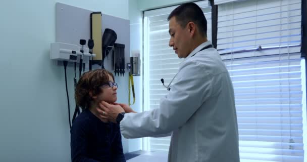 Vista Lateral Joven Médico Asiático Que Examina Niño Caucásico Una — Vídeo de stock