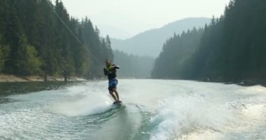 Önden Görünümü üzerinde şehir nehre wakeboard yapan beyaz delikanlı. Wakeboard ip 4 k tutan binici