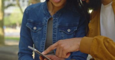 Mutlu Genç Asyalı Çift cep telefonu şehrin üzerinde tartışıyor. Birlikte 4 k şehirde oturan genç Asyalı Çift