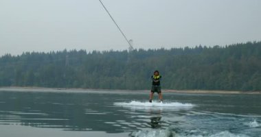 Önden Görünümü üzerinde şehir nehre wakeboard yapan beyaz delikanlı. Wakeboard ip 4 k tutan binici