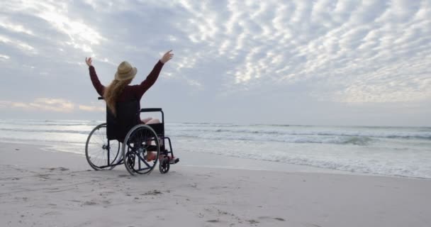 Visão Traseira Jovem Mulher Caucasiana Deficiente Chapéu Sentado Cadeira Rodas — Vídeo de Stock