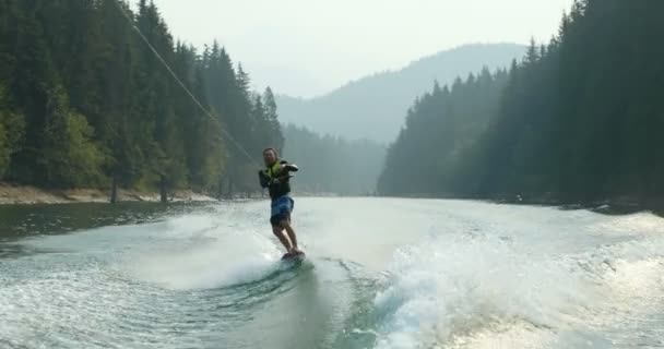 Vista Frontal Del Joven Caucásico Haciendo Trucos Wakeboard Río Ciudad — Vídeos de Stock