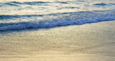 Sahilde kıyıya doğru ulaşan güzel deniz dalgaları. 4k alacakaranlıkta dalgalar deniz