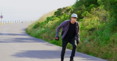 Serin Genç beyaz kaykaycılar yokuş aşağı kırsal üzerinde paten önden görünümü. Onlar güneş 4 k kaykay üzerinde sürme